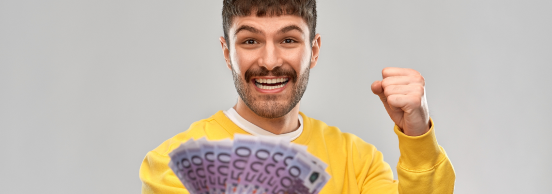 Abbildung Eine junger Mann mit mehreren fünfhundert Euro Scheinen in der Hand 